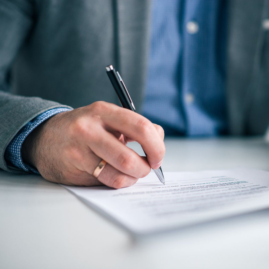 Man's hand signing a contract