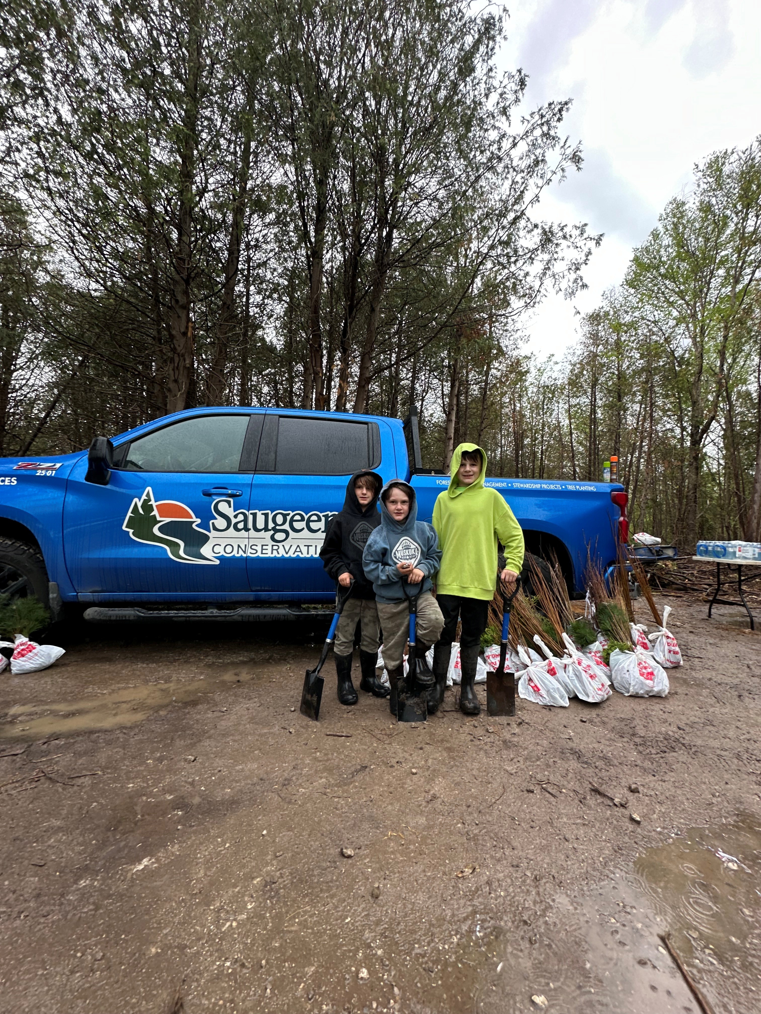Wyatt, Austin and Easton Harrigan prepare to plant trees.  They came prepared with their own shovels!