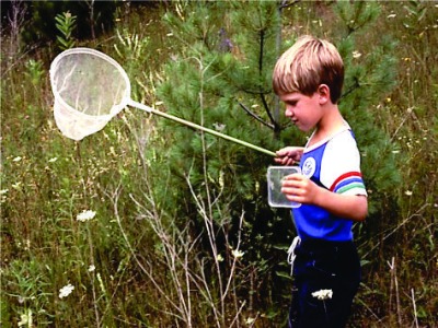 Child with a net in a field